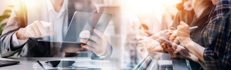 Financial analysts analyze business financial reports on a digital tablet planning investment project during a discussion at a meeting of corporate showing the results of their successful teamwork.