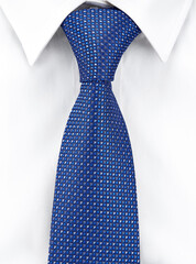 Close-up of a necktie made of blue silk with a geometric pattern, tied with a Windsor knot on a white shirt with a classic collar. Vertical image.