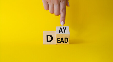 Day of the Dead symbol. Businessman hand points at turned wooden cubes with words Day of the Dead. Beautiful yellow background. Day of the Dead concept. Copy space.
