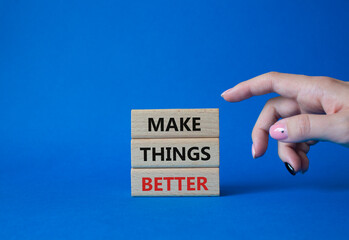 Make things better symbol. Concept word Make things better on wooden blocks. Businessman hand. Beautiful blue background. Business and Make things better concept. Copy space