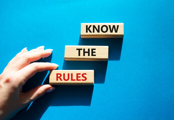 Know the rules symbol. Wooden blocks with words Know the rules. Beautiful blue background. Businessman hand. Business and Know the rules concept. Copy space.