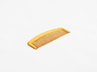 A wooden comb on a white background with copy space