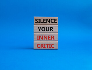 Silence your inner critic symbol. Wooden blocks with words Silence your inner critic. Beautiful blue background. Business and Silence your inner critic concept. Copy space.