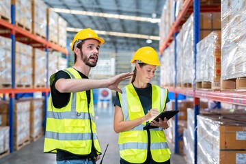 Warehouse worker standing check stock quantity of product and key information to tablet pc