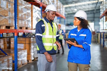 Warehouse worker standing discussion talking stock check and key information to tablet pc