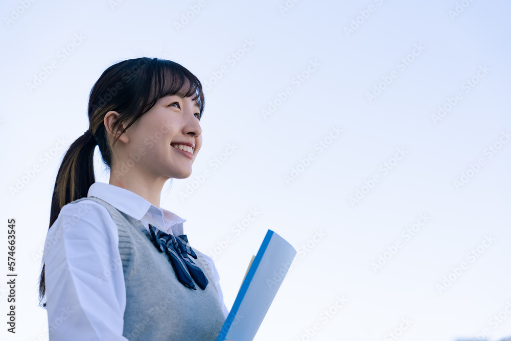 Wall mural 外で遠くを見る制服を着た女子高生