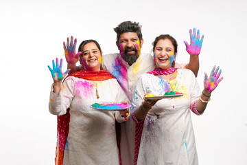 Young indian people showing colors hand and celebrating holi festival.