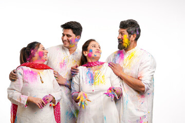 Young indian people celebrating holi festival on white background.