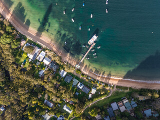Bird's eye aerial view of Great Mackerel Beach & Wharf on the western shores of Pittwater in Ku-ring-gai Chase National Park, Sydney, NSW, Australia. Mackerel can be reached via ferry from Palm Beach.