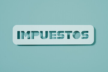pale blue paper signwith the text taxes in spanish