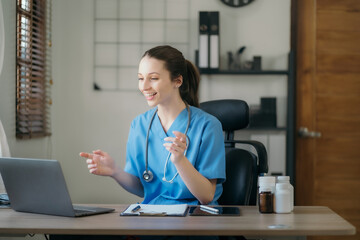 Doctor and patient are discussing something, conducts video consultation the table at clinic.