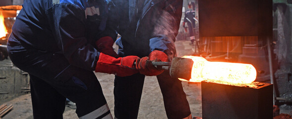 The interior of the forge. Blacksmiths during the process of forging iron. Forging of steel parts.