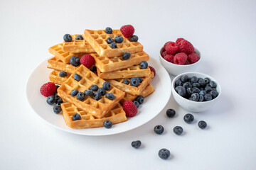 Traditional Belgian waffles with blueberries and raspberries for breakfast