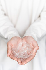 woman's hand holds invisible aligners on a white background of her sweater, close-up. Girl in full growth holds a handful of aligners in her palms