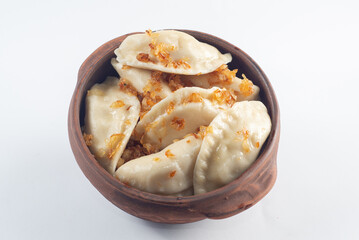 Boiled dumplings seasoned with spices in a plate on a white background.