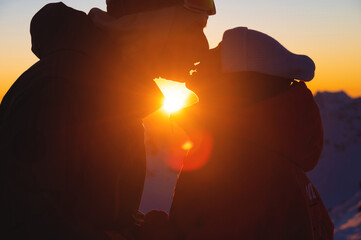 Silhouette of a couple kissing against the backdrop of sunset. Silhouette of a young couple loving each other against the backdrop of sunset. Couple in love at sunset in the mountains