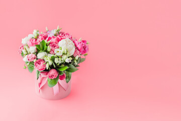 Arrangement of flowers in a hat box. Bouquet of peonies, eustoma, spray rose in a pink box with an...