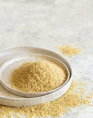 Raw Dry bulgur wheat grain on a plate close up, copy space. Vegetarian and Middle Eastern cuisine