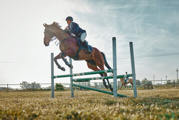Training, competition and woman on a horse for sports, an event or show on a field in Norway. Jump,...