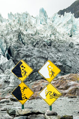 warning sign in franz josef glacier with edge of the glacier in the background, south island new zealand