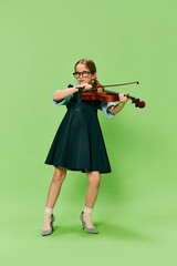 Cute little girl, talanted musician wearing huge mother's heels shoes playing violin, having fun...