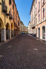Naklejka na ściany i meble cobbled street with historic tenement houses with shadows in the city of Padua