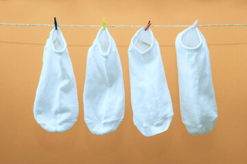 Four white socks hang on trailers. White socks dry after washing.