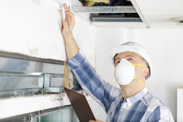 man using a protective mask working on ceiling