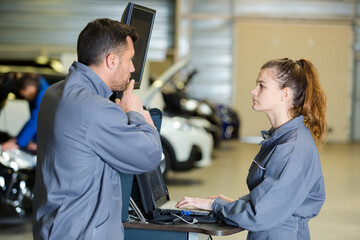 mechanic training female apprentice to use computerised equipment
