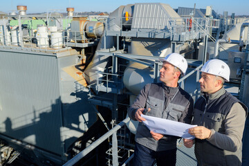 businessmen in hardhats standing and discussing outdoors