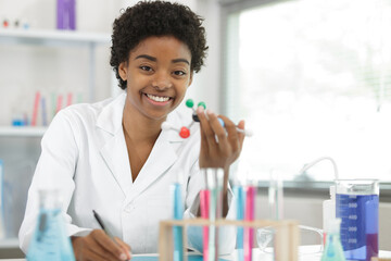 cheerful young scientist holding a model of a dna