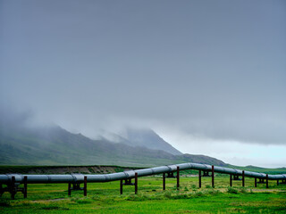 Fog and mist near the village of Nuiqsut Alaska near the North Slope with the Dietrich River and the Alaska Pipeline in the foreground showing the pipeline raised for animal crossing - 574687997