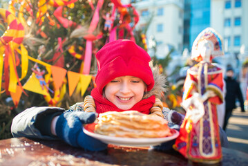 smiling boy going to eat pancakes  at the traditional Russian festival dedicated to the meeting of spring, the week of pancakes, Shrovetide. decorations for the Maslenitsa holiday