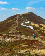 Fototapeta premium Beautiful fit happy girl in pink jacket enjoys hike in stunning colorful mountain scenery. Spring in the Bieszczady Mountains, Poland, Europe