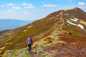 Naklejka premium Backpacker girl enjoys a hike during spring in the Bieszczady Mountains, Poland, Europe