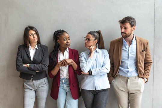 Group of young business people colleagues freelancers experts leaders of different professions in a company of marketing and financial experts standing leaning against wall with different attitude