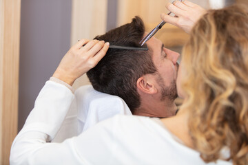 Obraz na płótnie Canvas pretty woman working as a hairdresser and cutting hair