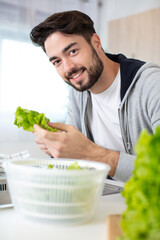 young man preparing healthy vegetable salad