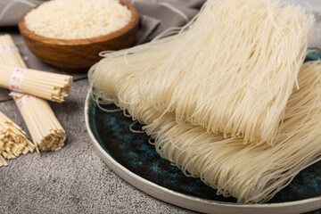Dried raw rice noodles and rice on a light texture background.Noodles with rice flour. Funchoza. Diet food. Healthy food. Place for text. Place for copying.