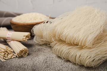 Dried raw rice noodles and rice on a light texture background.Noodles with rice flour. Funchoza. Diet food. Healthy food. Place for text. Place for copying.