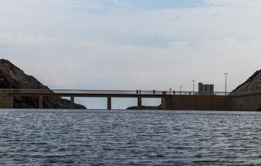 Obraz premium Shot of a people crossing the bridge above the water. Outdoors