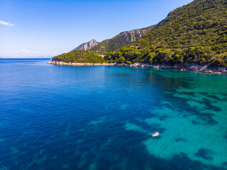a girl in a bikini swims on a watermelon-shaped mattress with beautiful green mountains in the...