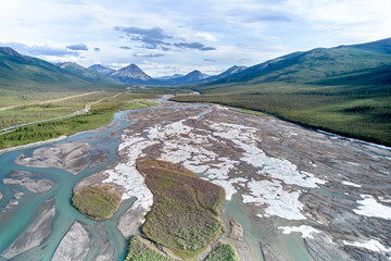 Aerial drone image of Fresh July Snow on the braided looking Dietrich River between the Coldfoot Camp and Prudhoe bay in Alaska with the Trans-Alaska Oil Pipeline