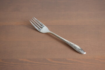 A silver fork on the wooden table