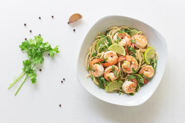 Shrimp pasta lemon coriander in white bowl on white background Italian food.