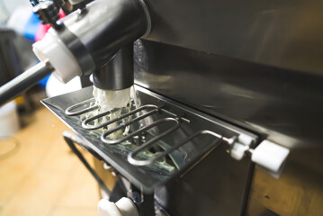 Pouring pasteurized ice cream formula out of batch machine. High quality photo