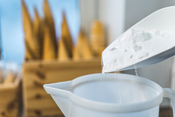 Pouring dry ingredients into ice cream mix. High quality photo