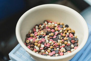 Mixed white, ruby, dark chocolate callets in a bowl. High quality photo