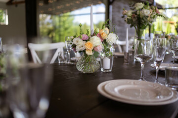 A very nicely decorated wedding table appointments with beautiful decor with plates and serviettes in spring garden. Beautiful flowers on table in wedding day. The elegant dinner table.