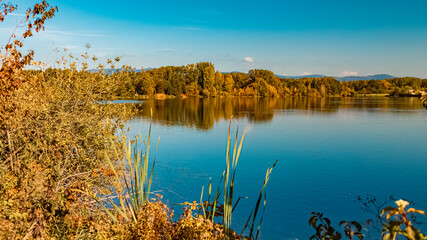 Beautiful autumn or indian summer landscape view with reflections at a pond near Plattling, Isar ,...